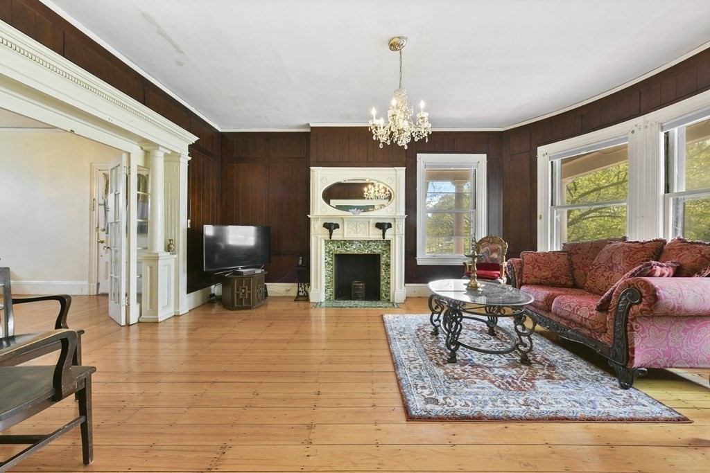 384 Arborway Boston, MA 02130 - Photo 7 of 39 a living room with furniture and a chandelier