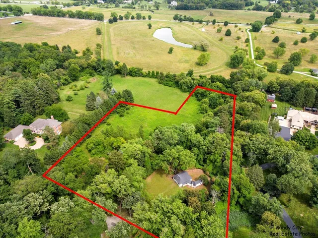 a view of a lake with a yard and large trees