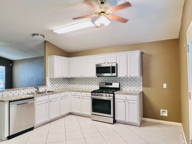 21606 Falvel Lake Drive Spring, TX 77388 - Photo 12 of 24 a kitchen with stainless steel appliances granite countertop a sink and dishwasher a stove top oven with wooden floor