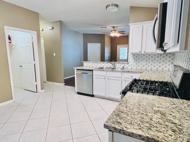 a kitchen with a sink a stove and cabinets
