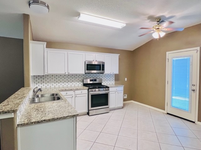 21606 Falvel Lake Drive Spring, TX 77388 - Photo 14 of 24 a kitchen with granite countertop a sink a stove top oven and cabinets