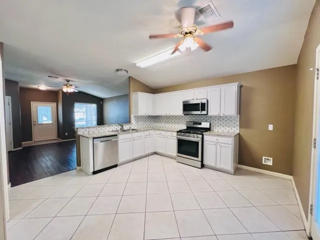 a kitchen with granite countertop a refrigerator and a stove top oven