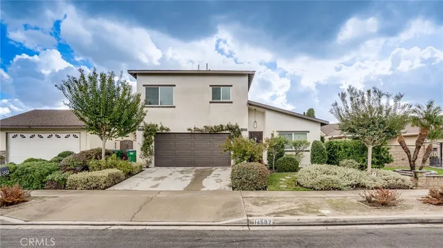 a front view of a house with a garden and plants