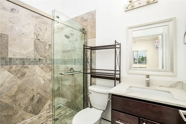 a bathroom with a sink toilet a mirror and shower