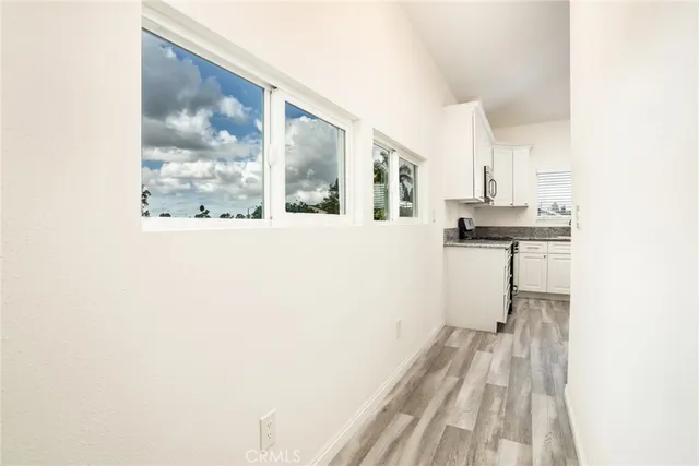 a view of a kitchen with wooden floor and a large window