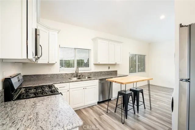a kitchen with stainless steel appliances granite countertop a stove a sink and a refrigerator