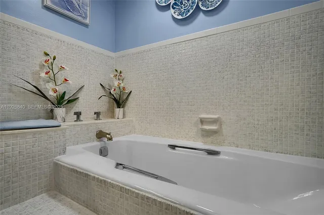 a bedroom with a bed a dresser and painting on the wall