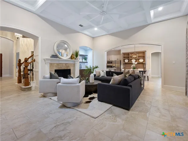 a living room with furniture a fireplace and a chandelier