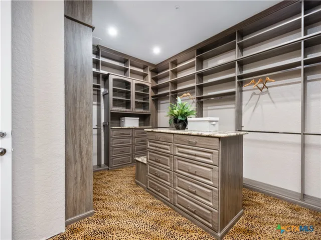 a view of walk in closet and wooden floor