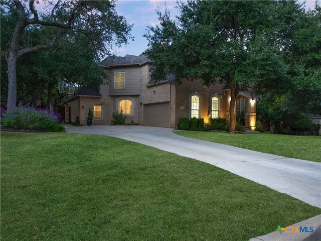 a front view of a house with a yard and trees