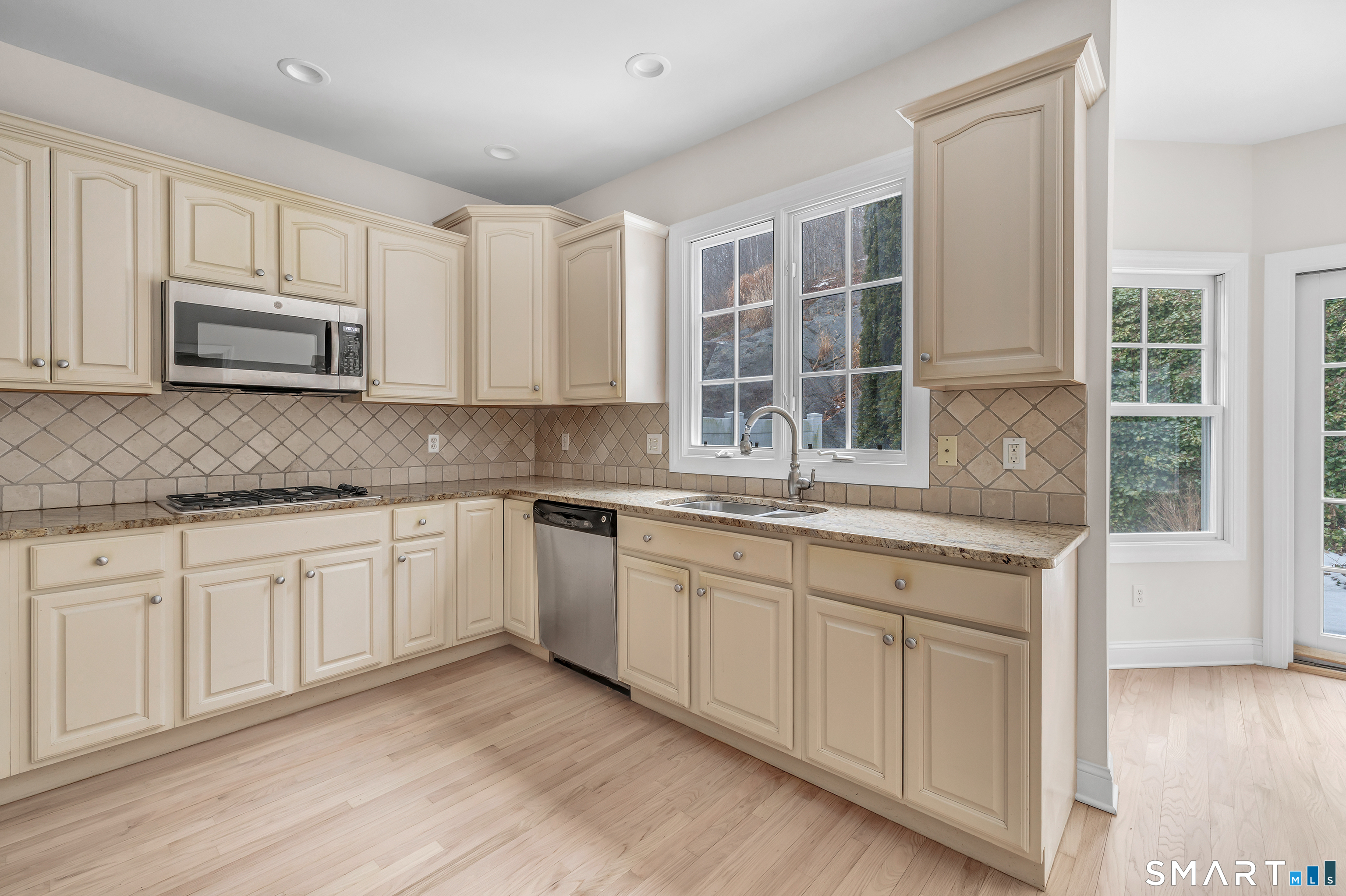 665 River Road, Unit 2 Shelton, CT 06484 - Photo 12 of 33 a kitchen with granite countertop cabinets stainless steel appliances a sink and a window