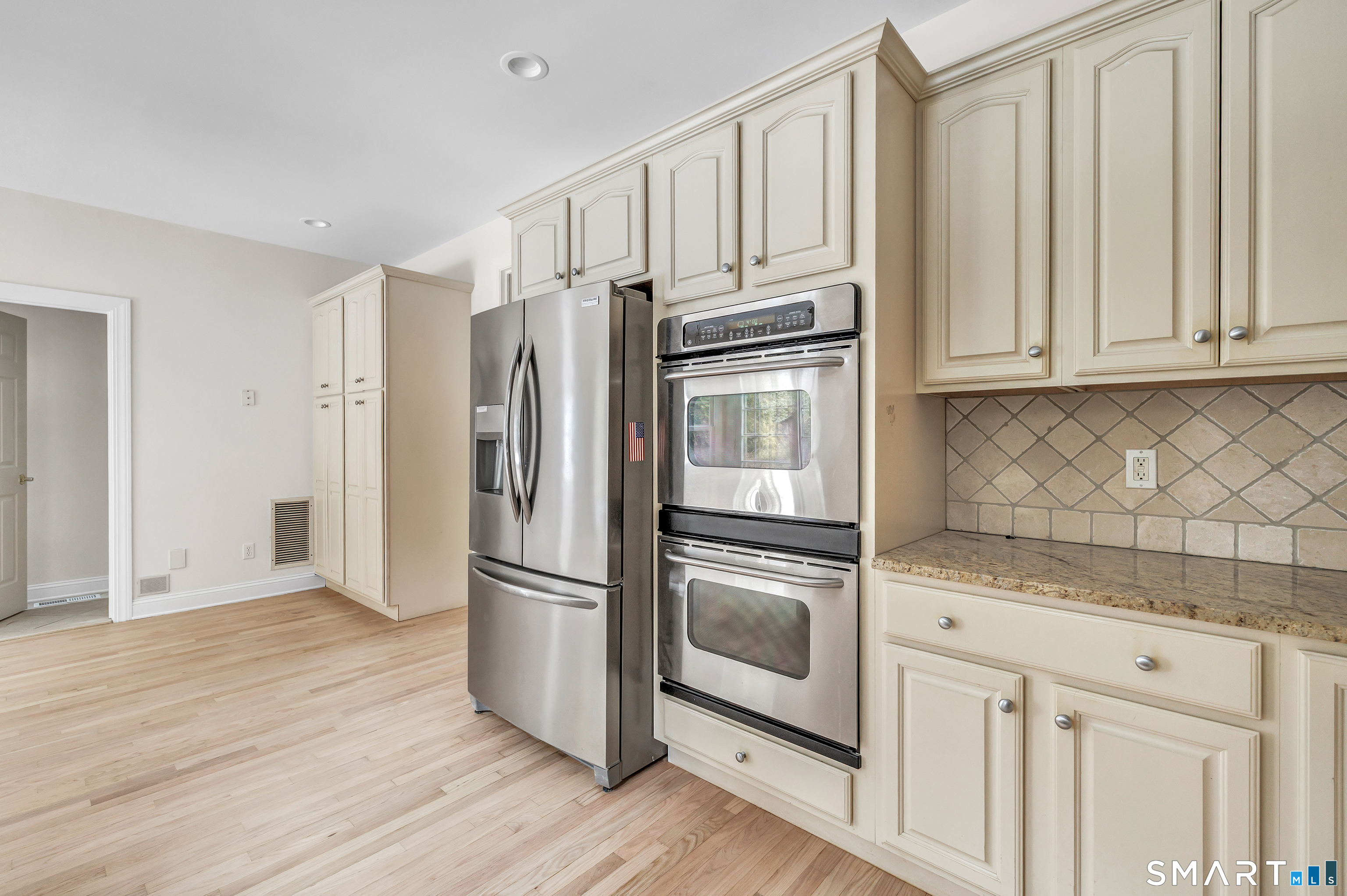 665 River Road, Unit 2 Shelton, CT 06484 - Photo 13 of 33 a kitchen with granite countertop a refrigerator and cabinets