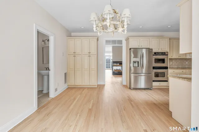 a view of a kitchen with stainless steel appliances a refrigerator and wooden floor