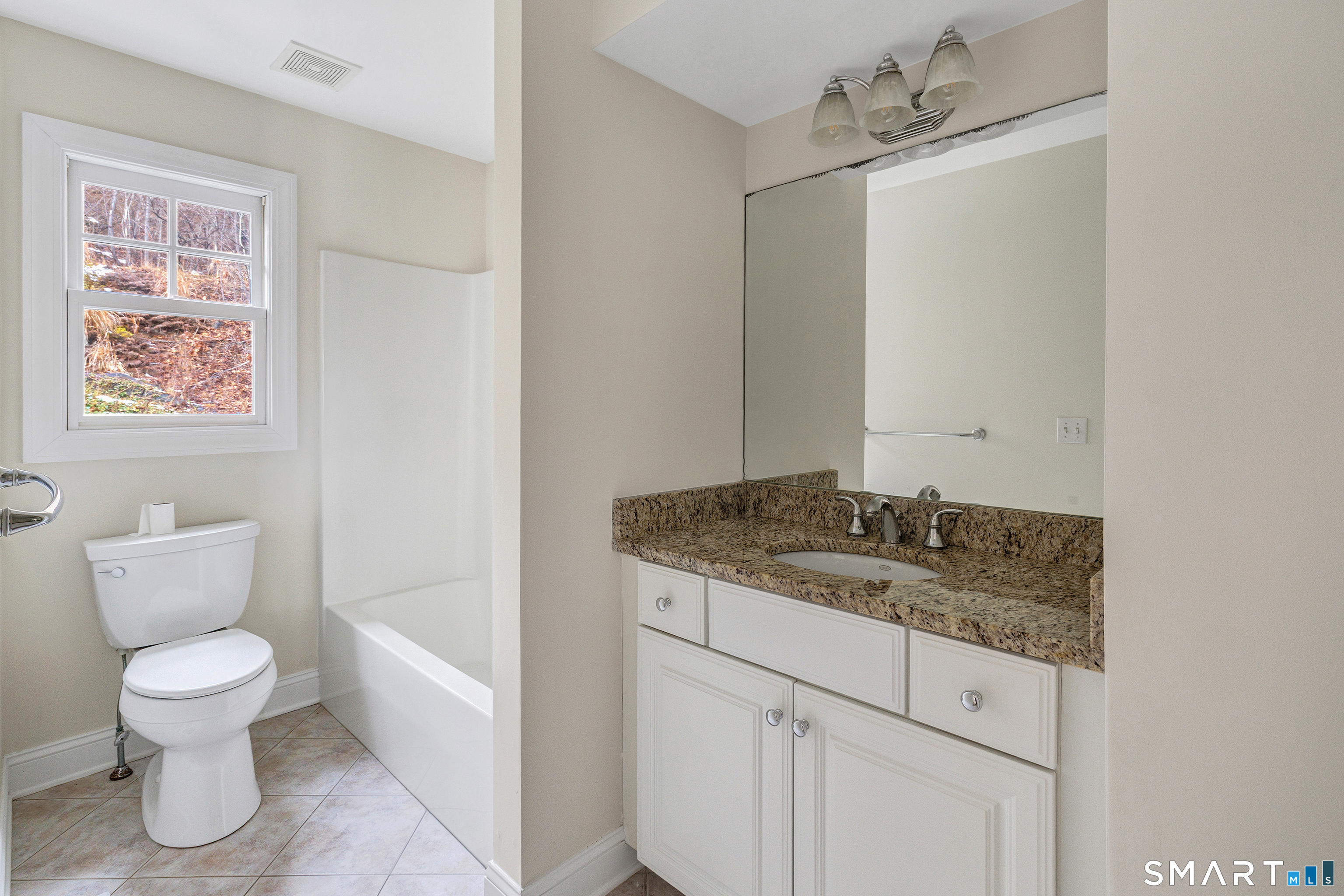 665 River Road, Unit 2 Shelton, CT 06484 - Photo 20 of 33 a bathroom with a granite countertop sink a toilet and a mirror