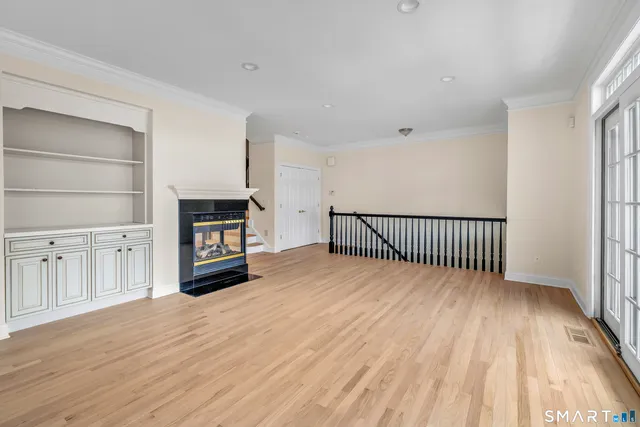 a view of a hallway with wooden floor and a fireplace