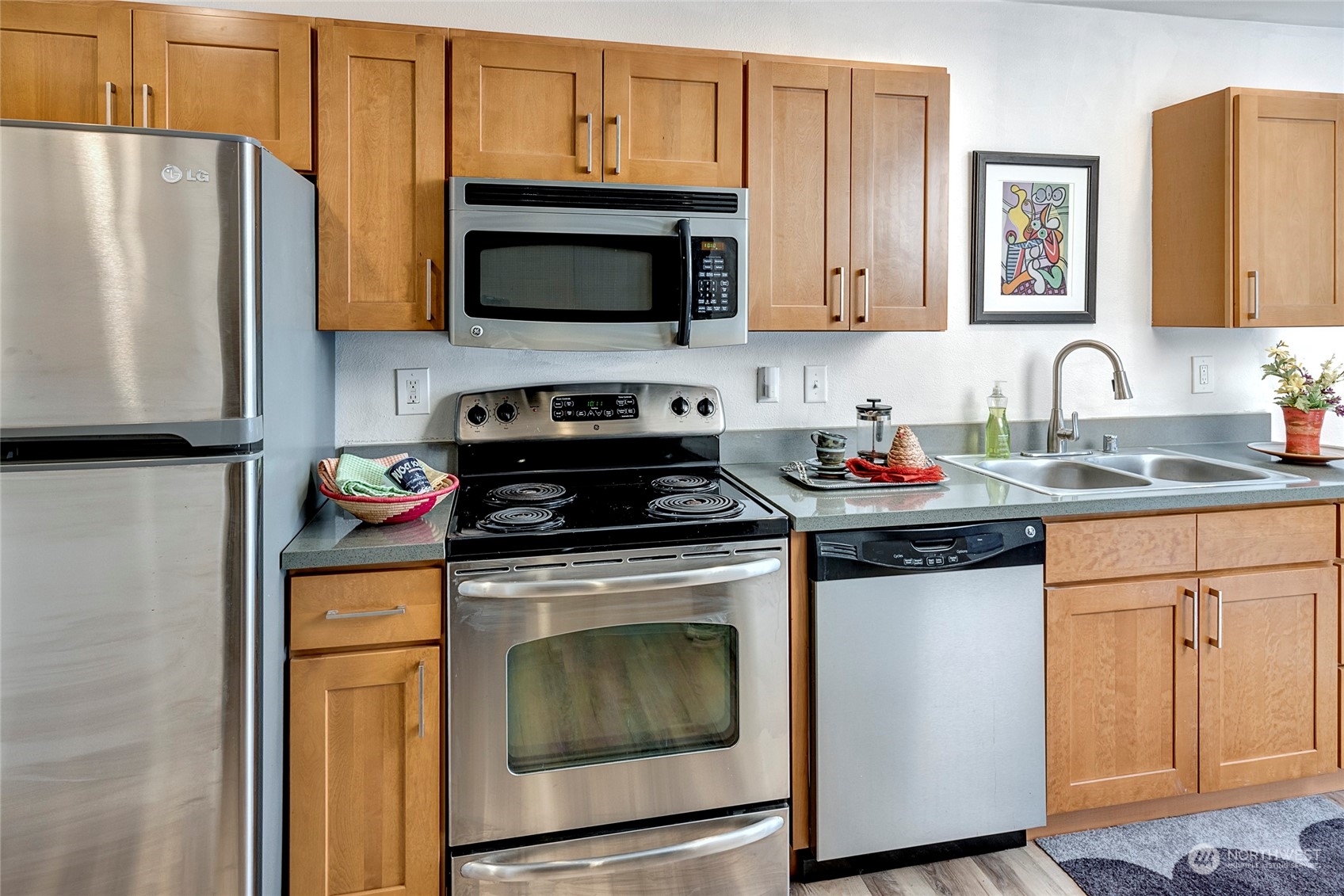 3028 Western Avenue, Unit 408 Seattle, WA 98121 - Photo 27 of 40 a kitchen with stainless steel appliances granite countertop a stove a microwave and a refrigerator
