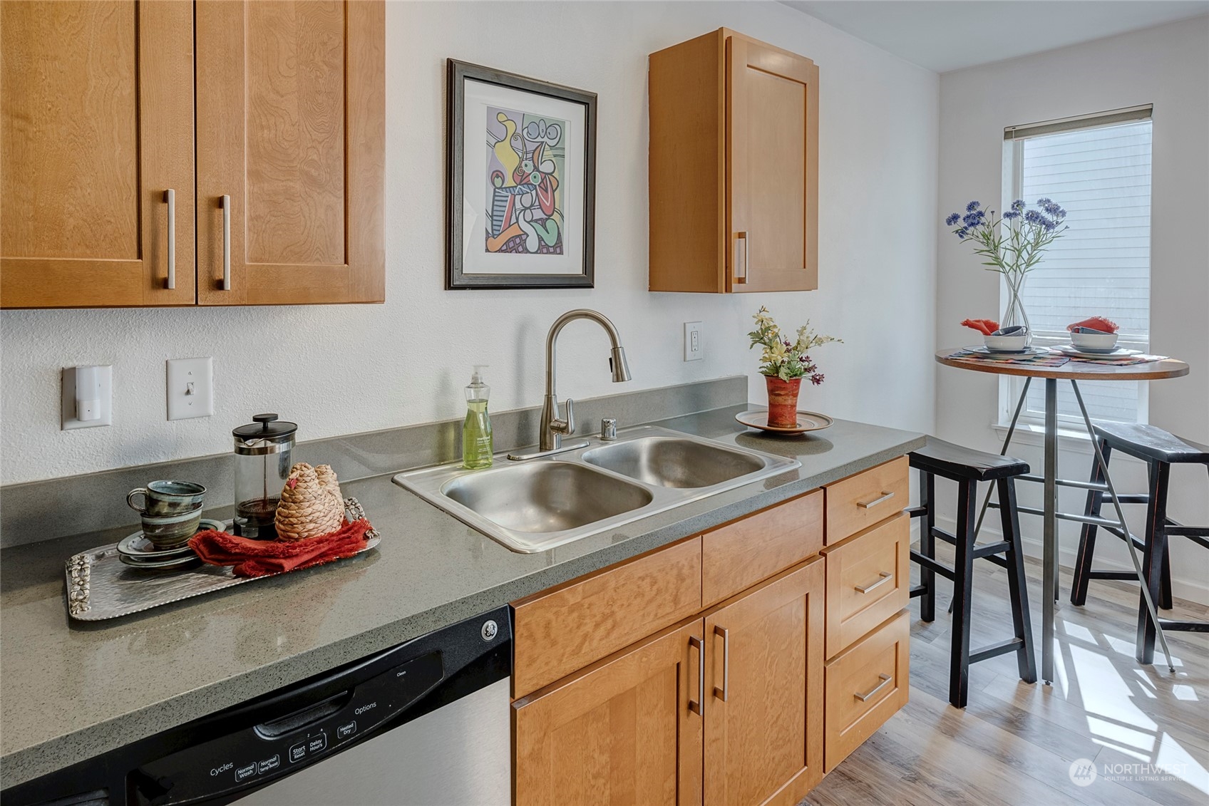 3028 Western Avenue, Unit 408 Seattle, WA 98121 - Photo 5 of 40 a kitchen with stainless steel appliances a sink a stove and white cabinets with wooden floor