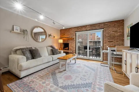 a living room with furniture a flat screen tv and a large window