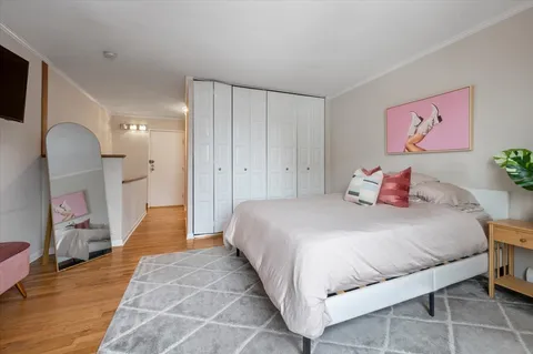 a bedroom with a bed and a large mirror on dresser