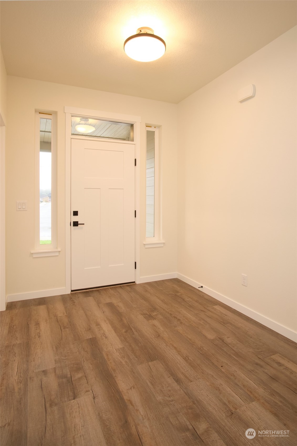 1070 Rw Fletcher Street Winlock, WA 98596 - Photo 2 of 21 an empty room with wooden floor and windows