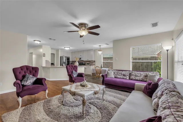 a living room with furniture kitchen view and a large window