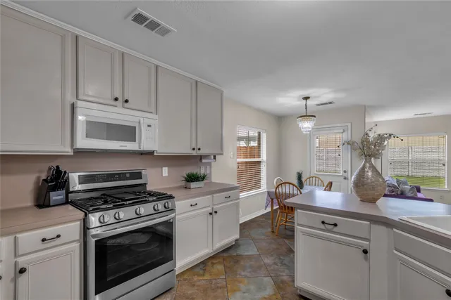 a kitchen with white cabinets and appliances