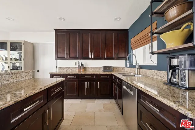 a kitchen with granite countertop a sink stove and cabinets