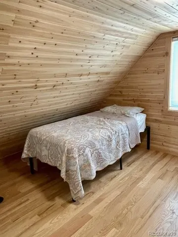 a bedroom with a bed and a wooden floor