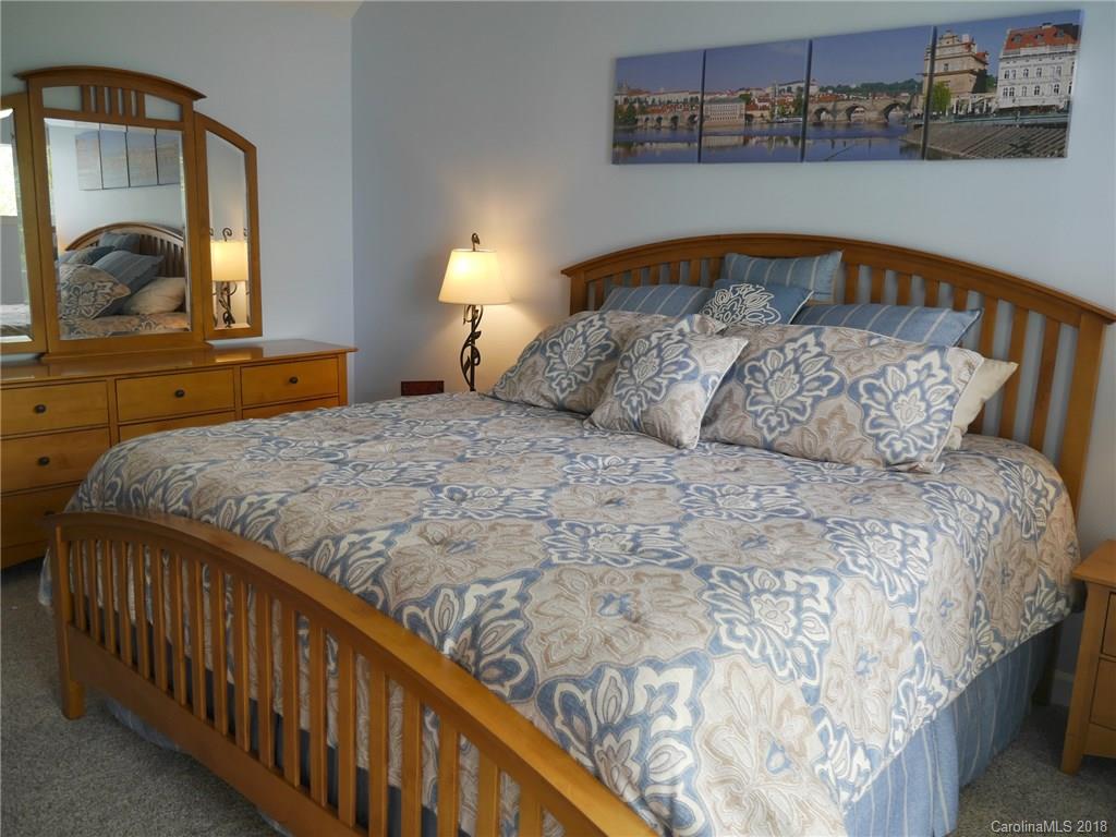 17925 Kings Point Drive, Unit F Cornelius, NC 28031 - Photo 6 of 36 a bedroom with a large bed and a mirror on the dresser