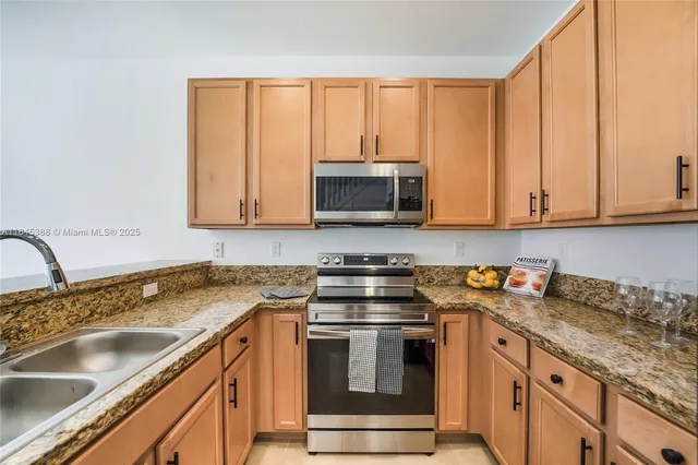 a kitchen with granite countertop a sink and a stove top oven