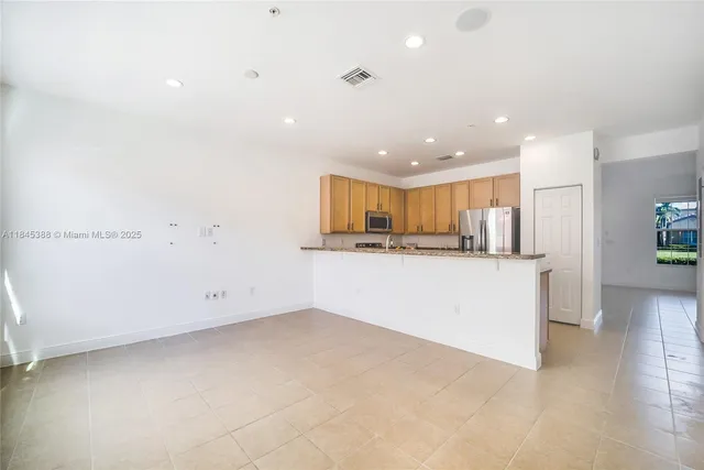 a view of kitchen with kitchen island white cabinets and refrigerator