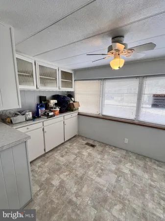 en empty room with windows and ceiling fan