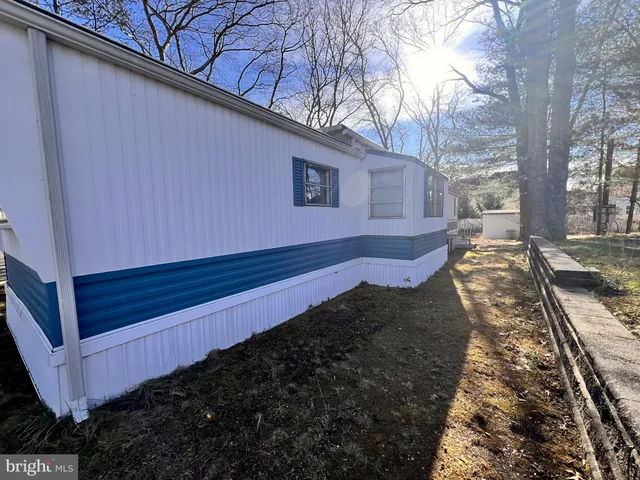 a view of a backyard with wooden fence and large trees
