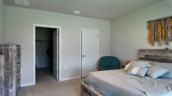 a bedroom with a bed and a painting on the wall