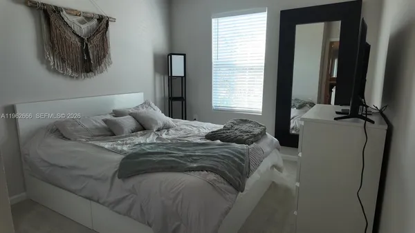 a bed sitting in a bedroom next to a window