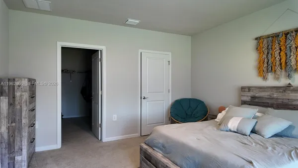 a bedroom with a bed and a painting on the wall