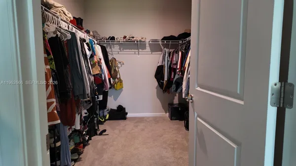 a view of walk in closet with clothes