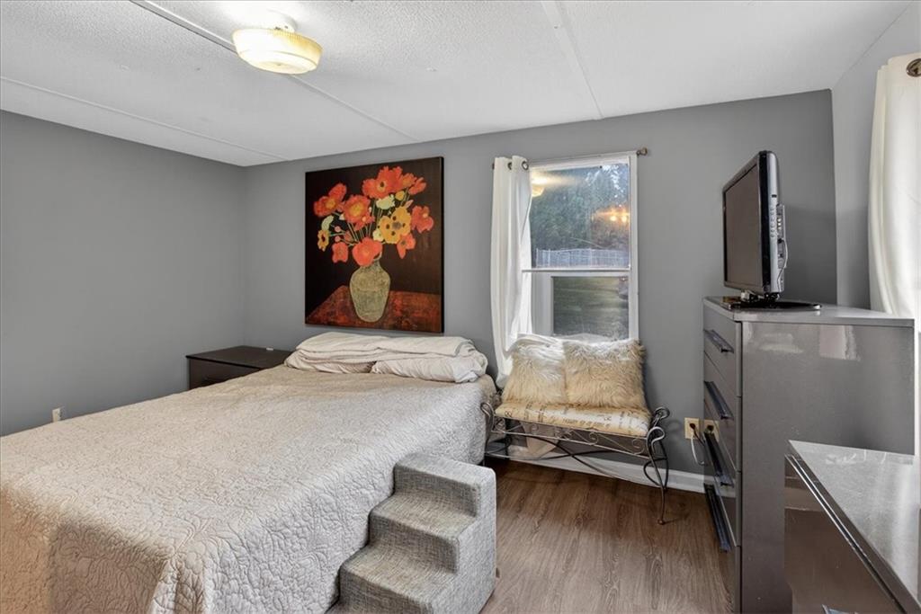 323 Ball Field Road Waleska, GA 30183 - Photo 11 of 39 a bedroom with a bed and a flat tv screen on the dresser