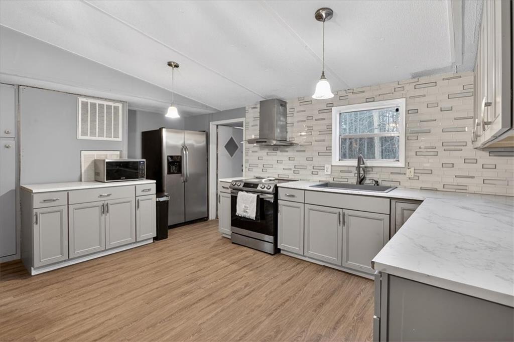 323 Ball Field Road Waleska, GA 30183 - Photo 9 of 39 a kitchen with stainless steel appliances kitchen island granite countertop a sink cabinets and wooden floor