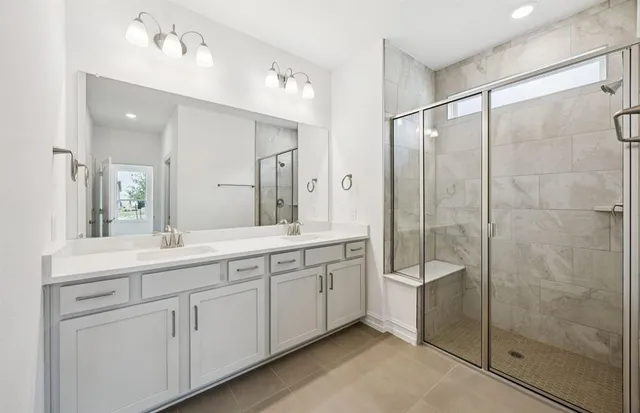 a spacious bathroom with a shower sink and mirror