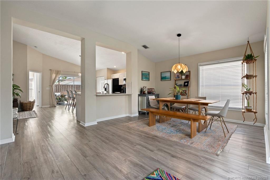 6351 Adams Street Jupiter, FL 33458 - Photo 12 of 42 a living room with furniture a wooden floor and a large window