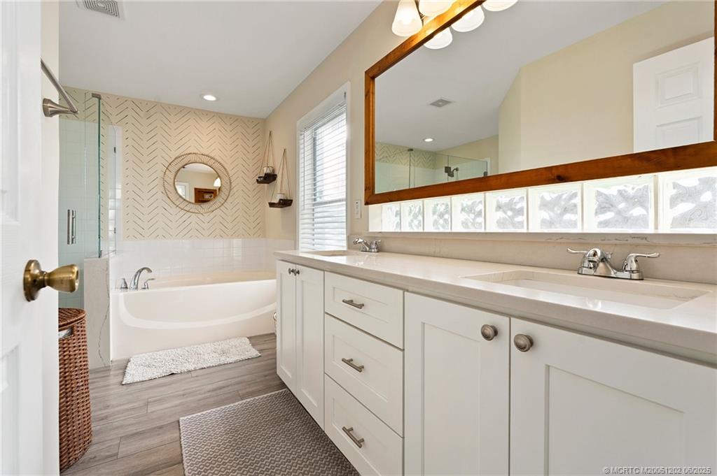 6351 Adams Street Jupiter, FL 33458 - Photo 22 of 42 a bathroom with a tub a sink and a large window