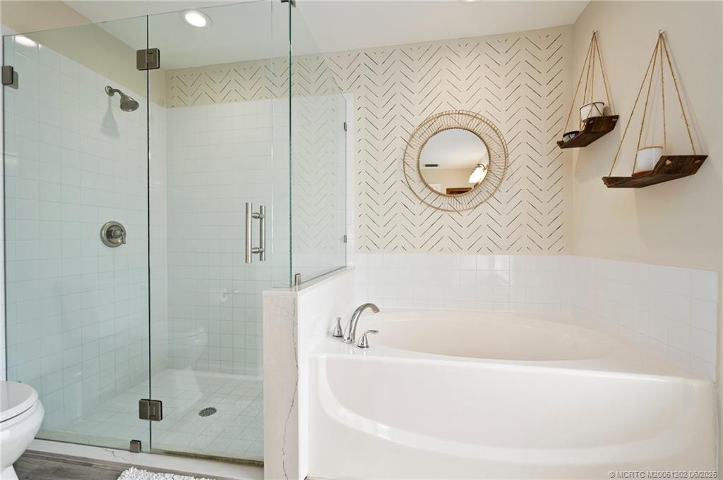 6351 Adams Street Jupiter, FL 33458 - Photo 24 of 42 a bathroom with a bathtub and a shower