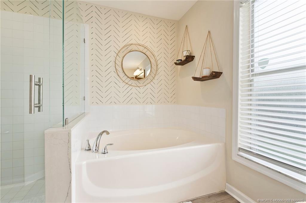6351 Adams Street Jupiter, FL 33458 - Photo 25 of 42 a bathroom with a tub and a shower