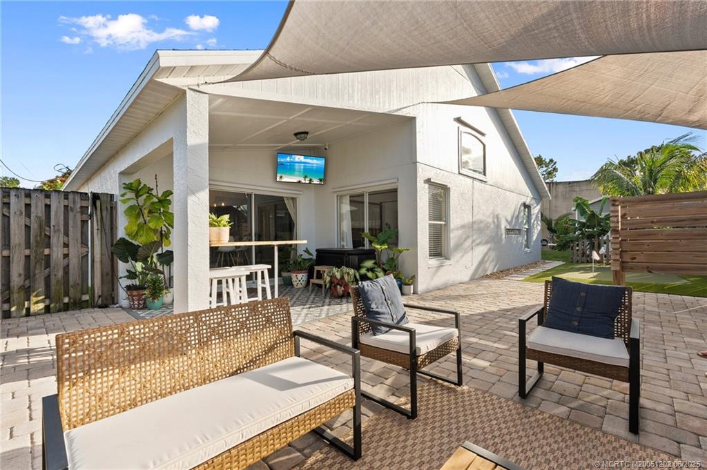6351 Adams Street Jupiter, FL 33458 - Photo 35 of 42 a view of a patio with couches table and chairs and potted plants