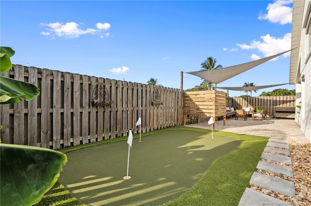 6351 Adams Street Jupiter, FL 33458 - Photo 37 of 42 a view of a swimming pool with a patio and a garden