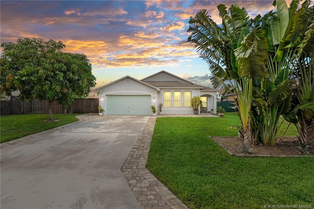 6351 Adams Street Jupiter, FL 33458 - Photo 4 of 42 a front view of a house with a garden