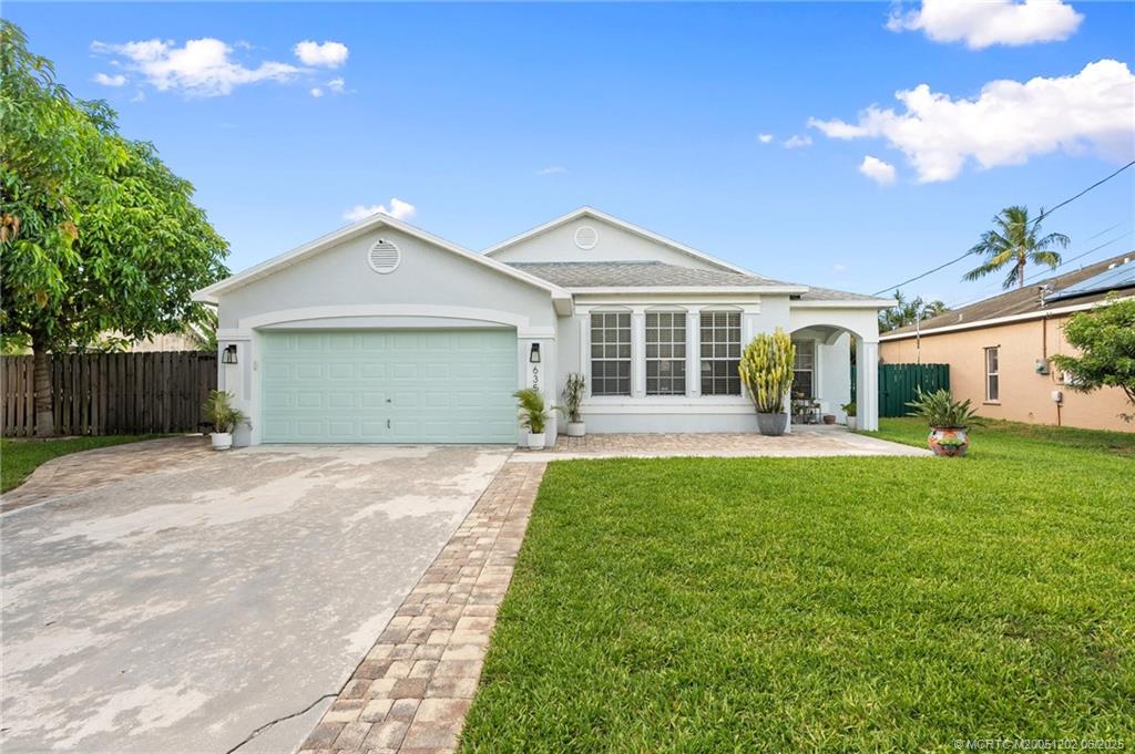 6351 Adams Street Jupiter, FL 33458 - Photo 42 of 42 a front view of a house with a yard and garage
