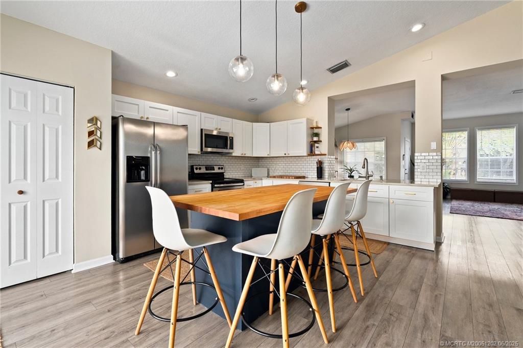 6351 Adams Street Jupiter, FL 33458 - Photo 5 of 42 a view of a dining room with furniture and wooden floor