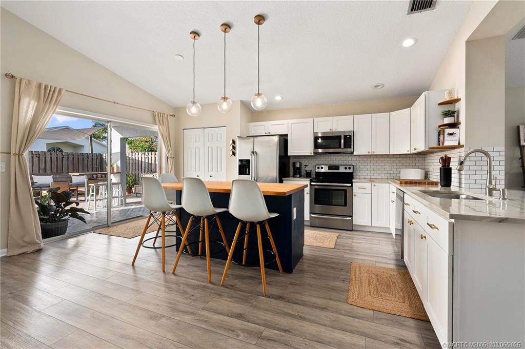 6351 Adams Street Jupiter, FL 33458 - Photo 7 of 42 a large kitchen with kitchen island a large island in the center